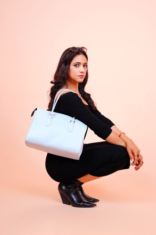 A woman holding a white leather tote bag