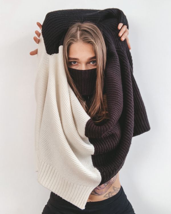 A woman holding a chunky cream knit